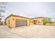 Stucco home featuring a spacious driveway leading to attached garages on an expansive lot at 8210 S 132Nd Ave, Goodyear, AZ 85338