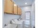 Laundry room featuring a sink, counter space, wooden cabinets, and a washer and dryer set at 8210 S 132Nd Ave, Goodyear, AZ 85338