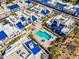 An aerial view showcasing white stucco homes with vibrant blue roofs centered around a community pool and spa at 10 W Georgia Ave # 8, Phoenix, AZ 85013