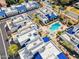 An aerial view of white stucco homes with vibrant blue roofs surrounding a sparkling pool and hot tub at 10 W Georgia Ave # 8, Phoenix, AZ 85013