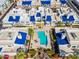 Birds eye view of homes with royal blue roofs surrounding a community pool, spa, and common green spaces at 10 W Georgia Ave # 8, Phoenix, AZ 85013