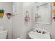 Cozy half-bathroom featuring a pedestal sink, decorative mirror, and window with plantation shutters at 10 W Georgia Ave # 8, Phoenix, AZ 85013