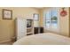 Bedroom featuring a window with shutters, a mounted television, and bedside table at 10 W Georgia Ave # 8, Phoenix, AZ 85013