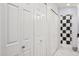 Hallway with multiple closets and a view into a bathroom with checkered shower at 10 W Georgia Ave # 8, Phoenix, AZ 85013