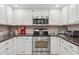 Updated kitchen showcasing stainless steel appliances, white cabinetry, and dark granite countertops at 10 W Georgia Ave # 8, Phoenix, AZ 85013