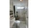 Bright bathroom featuring a modern vanity, built-in shelving, toilet, and a tiled walk-in shower with a window at 1118 S Shawnee Dr, Apache Junction, AZ 85119