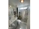 Bright bathroom featuring a modern vanity, built-in shelving, toilet, and a tiled walk-in shower with a window at 1118 S Shawnee Dr, Apache Junction, AZ 85119