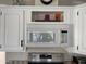 Modern white microwave installed above a stainless steel range with decor on cabinets at 1118 S Shawnee Dr, Apache Junction, AZ 85119