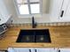 Close up on a kitchen sink with a wood countertop and black faucet at 1118 S Shawnee Dr, Apache Junction, AZ 85119