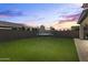 Green backyard featuring artificial turf, and trampoline at sunset at 11607 W Marguerite Ave, Avondale, AZ 85323