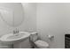 Clean, minimalist half-bathroom with a pedestal sink and modern toilet at 11607 W Marguerite Ave, Avondale, AZ 85323