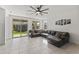 Spacious living room with a ceiling fan, sliding door, and comfortable leather sectional sofa at 11607 W Marguerite Ave, Avondale, AZ 85323