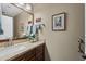 Bathroom vanity with wooden cabinets, neutral countertops, framed mirror, and decor at 1198 Leisure World --, Mesa, AZ 85206