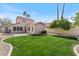Spacious backyard features manicured lawn, mature trees, and block fence at 1518 E Mineral Rd, Gilbert, AZ 85234