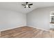 Bedroom features wood-look flooring, a ceiling fan, neutral paint, and adjoins a bathroom at 1518 E Mineral Rd, Gilbert, AZ 85234