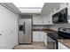 Functional kitchen boasts stainless steel appliances, granite counters, white cabinets, and laminate flooring at 1518 E Mineral Rd, Gilbert, AZ 85234