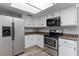 Well-equipped kitchen features stainless steel appliances, white cabinetry, and granite countertops for a modern touch at 1518 E Mineral Rd, Gilbert, AZ 85234