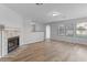 Inviting living room with a fireplace, laminate floors, and large windows offering plenty of natural light at 1518 E Mineral Rd, Gilbert, AZ 85234