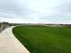 Lush green community park with walking path at 15709 W Beryl Ave, Waddell, AZ 85355