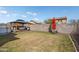 Large backyard featuring a gazebo with lounge set, a red umbrella, and a block fence for privacy at 18040 W Louise Dr, Surprise, AZ 85387