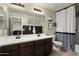 Bathroom with dual sinks, dark wood cabinets, and a modern design, combining style and functionality at 18040 W Louise Dr, Surprise, AZ 85387
