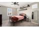 Bright bedroom with a black metal bed frame, floating shelves, and shutters, offering a sleek and modern space at 18040 W Louise Dr, Surprise, AZ 85387