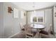 Bright dining room with a round table, white chairs, and large window with bright, natural light at 18040 W Louise Dr, Surprise, AZ 85387