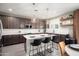 Spacious kitchen with a large island, dark cabinetry, and modern lighting fixtures at 18040 W Louise Dr, Surprise, AZ 85387