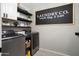 Modern laundry room featuring black cabinets, open shelving, and updated appliances for efficient organization at 18040 W Louise Dr, Surprise, AZ 85387