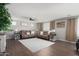 Spacious living room with a ceiling fan, plush sofas, and large area rug at 18040 W Louise Dr, Surprise, AZ 85387