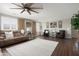 A well-lit living room features a ceiling fan, plush sofas, and a decorative area rug at 18040 W Louise Dr, Surprise, AZ 85387