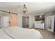 Main bedroom with a sliding barn door, stylish light fixture, and neutral tones for a serene atmosphere at 18040 W Louise Dr, Surprise, AZ 85387
