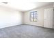 Bedroom featuring plush carpeting, white walls, a window, and an interior door at 19801 W Badgett Ln, Litchfield Park, AZ 85340