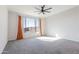 Carpeted bedroom featuring a large window and an overhead fan at 19801 W Badgett Ln, Litchfield Park, AZ 85340