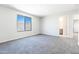 Spacious carpeted bedroom featuring a window and an open doorway at 19801 W Badgett Ln, Litchfield Park, AZ 85340