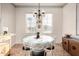 Well-lit dining room with stylish chandelier, round table, and views of the outdoors at 19975 N Crescent Way, Surprise, AZ 85374