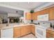 View of the kitchen with oak cabinets and a pass through to another room featuring green plants at 19975 N Crescent Way, Surprise, AZ 85374