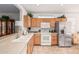 Bright kitchen featuring wood cabinets, stainless steel refrigerator, and white appliances at 19975 N Crescent Way, Surprise, AZ 85374