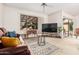 Bright living room featuring a large window, leather sofa, and stylish rug at 19975 N Crescent Way, Surprise, AZ 85374