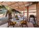 Charming covered patio with a dining set, grill, and views of the well-maintained backyard at 19975 N Crescent Way, Surprise, AZ 85374