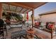 Inviting covered patio with a hammock, lounge chairs, stylish rug, and views of the landscaped backyard at 19975 N Crescent Way, Surprise, AZ 85374