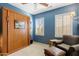 Bedroom with blue walls, murphy bed, white shutters, and reading chair at 20139 N Rawhide Way, Surprise, AZ 85387