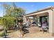 Covered patio area with outdoor seating, a grill, and a landscaped backyard at 20139 N Rawhide Way, Surprise, AZ 85387