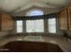 Charming kitchen with light-colored cabinets, beige counters, a double sink and a unique window above the sink at 2070 W Klamath Ave, Apache Junction, AZ 85119