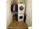 Well-organized laundry room with stacked washer and dryer, shelving, and storage space for efficient household tasks at 2070 W Klamath Ave, Apache Junction, AZ 85119