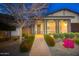Charming home exterior with a covered porch, landscaped yard, and brick walkway at twilight at 20906 E Macaw Dr, Queen Creek, AZ 85142