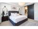 A spacious primary bedroom features a gray tufted headboard, barn door entrance to the en-suite bath and a lovely area rug at 20906 E Macaw Dr, Queen Creek, AZ 85142