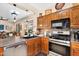 Kitchen featuring a stainless steel oven, wooden cabinets, a breakfast bar, and a view to dining area at 21141 E Stirrup St, Queen Creek, AZ 85142