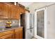 Kitchen featuring stainless steel fridge, wood cabinets and pantry with frosted sliding glass door at 21141 E Stirrup St, Queen Creek, AZ 85142