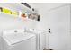 Well-lit laundry room featuring a modern washer and dryer set and storage shelving above at 21141 E Stirrup St, Queen Creek, AZ 85142